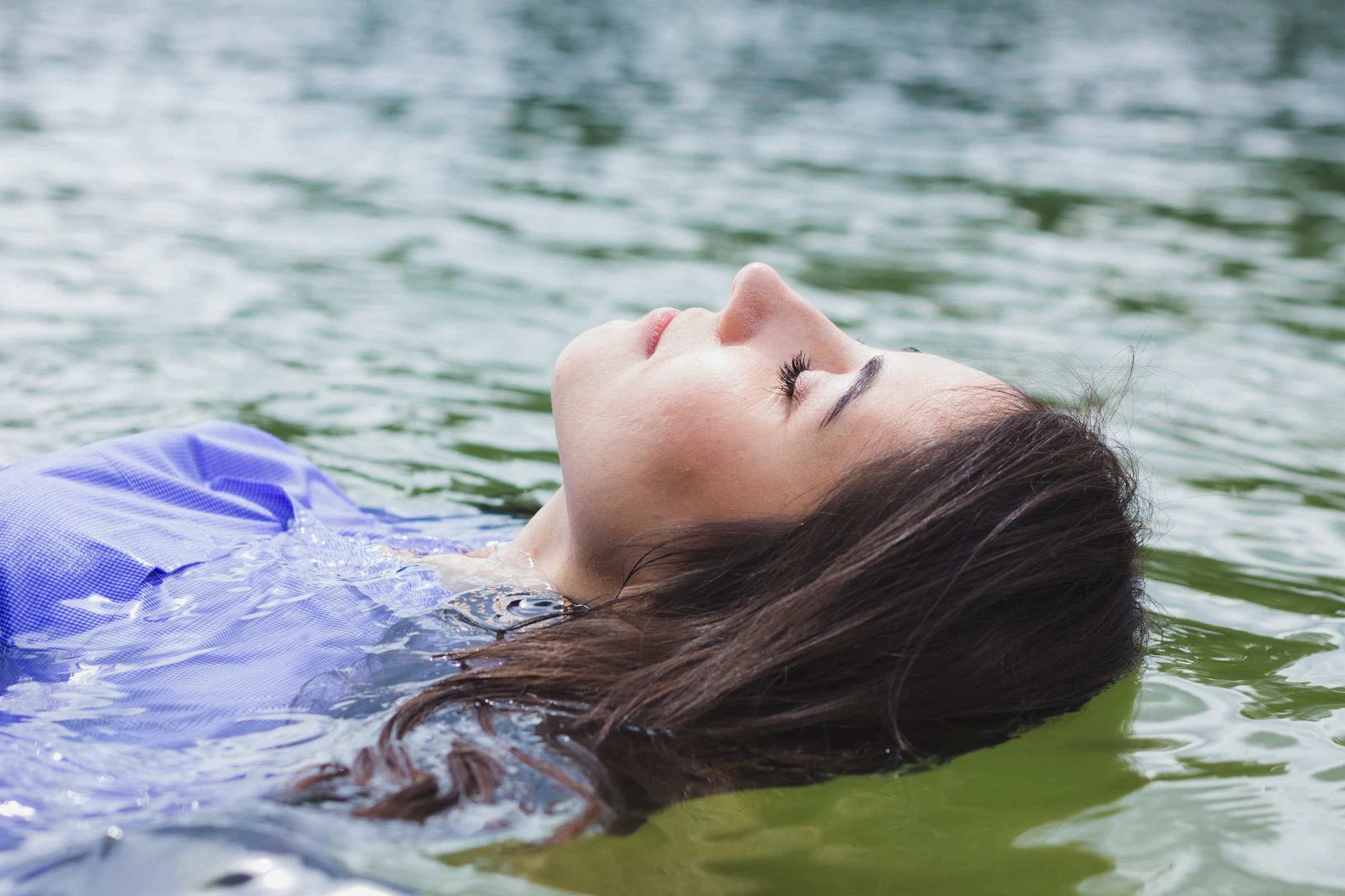 Femme flottant sur le dos, les yeux fermés